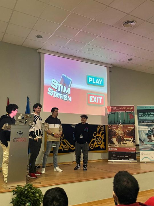 Un equipo presenta su juego con la pantalla de título proyectada